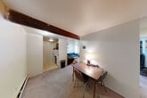 Located at 912 Brown St in Ann Arbor, Michigan, this two-bedroom, one-bathroom unit offers a compact and functional single-floor layout. The open living and dining area serves as the heart of the home, featuring carpet flooring, a distinctive exposed wood beam overhead, and an adjoining kitchen with tile flooring and standard appliances including a refrigerator and range. A balcony provides a welcome touch of outdoor access.

Both bedrooms are carpeted and offer ample natural light through large windows. The primary bedroom includes an open built-in closet with shelving and hanging space, with convenient access to the shared bathroom. The second bedroom also features its own closet. In total, the unit includes three closets, providing generous storage throughout. A hallway connects the main living areas to the bedrooms, adding a sense of separation and privacy.

The shared bathroom is straightforward and functional, featuring a vanity with sink, mirror, and a combined tub/shower. The overall layout is efficient, making practical use of the available space. With its proximity to the University of Michigan campus, this unit is well-suited for students or young professionals seeking a comfortable and conveniently located residence in Ann Arbor.
