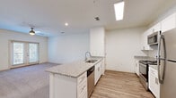 Located at 8240 Windsor Hill Blvd in North Charleston, SC, this single-floor, 4-bedroom, 2-bathroom residence offers a clean, modern design with a bright and neutral color palette throughout. The open-concept kitchen and living area serves as the heart of the home, anchored by a central island with granite countertops and an undermount sink. White shaker-style cabinetry, a subway tile backsplash, and a full suite of stainless steel appliances — including a refrigerator, range, microwave, and dishwasher — complete the well-appointed kitchen. Wood-look plank flooring runs through the kitchen and entry areas, while plush carpet extends into the living room and all four bedrooms. The spacious primary bedroom features double doors opening to a walk-in closet. Additional bedrooms are generously sized, each with soft carpet, ceiling fans, and windows that invite natural light. The two bathrooms echo the home's consistent design aesthetic, with granite-topped white vanities and wood-look flooring. One bathroom includes a glass-enclosed walk-in shower, while the other features a shower-tub combination. French doors in the living area provide access to an outdoor space, enhancing the overall openness and livability of this well-designed home.