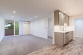 Located at 3700 Lillick Dr in Santa Clara, CA, this thoughtfully designed 2-bedroom, 1-bathroom single-floor residence offers a practical and comfortable layout. The galley-style kitchen is a standout feature, showcasing taupe shaker cabinetry, white quartz countertops, recessed lighting, stainless steel appliances including a dishwasher and range, and wood-look tile flooring that extends into the living area. The kitchen opens toward the living room, creating a cohesive common space that transitions from hard flooring to plush carpeting. Both bedrooms are carpeted and feature wall-mounted mini-split units for individual climate control. The primary bedroom is generously sized, includes a spacious walk-in closet with built-in shelving, and offers sliding door access to an outdoor balcony with lush green views. The second bedroom also benefits from natural light through a large window or sliding door with outdoor views and includes a standard closet with sliding doors. The full bathroom is finished in bright white tiling, featuring a tub-shower combo, quartz vanity top, and an in-unit washer conveniently integrated into the space. Throughout the residence, clean lines, neutral tones, and modern finishes create a fresh, move-in-ready ambiance.