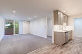 Located at 3700 Lillick Dr in Santa Clara, CA, this thoughtfully designed 2-bedroom, 1-bathroom single-floor residence offers a practical and comfortable layout. The galley-style kitchen is a standout feature, showcasing taupe shaker cabinetry, white quartz countertops, recessed lighting, stainless steel appliances including a dishwasher and range, and wood-look tile flooring that extends into the living area. The kitchen opens toward the living room, creating a cohesive common space that transitions from hard flooring to plush carpeting. Both bedrooms are carpeted and feature wall-mounted mini-split units for individual climate control. The primary bedroom is generously sized, includes a spacious walk-in closet with built-in shelving, and offers sliding door access to an outdoor balcony with lush green views. The second bedroom also benefits from natural light through a large window or sliding door with outdoor views and includes a standard closet with sliding doors. The full bathroom is finished in bright white tiling, featuring a tub-shower combo, quartz vanity top, and an in-unit washer conveniently integrated into the space. Throughout the residence, clean lines, neutral tones, and modern finishes create a fresh, move-in-ready ambiance.