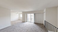 Located at 3404 Knights Rd in Bensalem, PA, this two-bedroom, two-bathroom residence spans two floors, with the majority of living space thoughtfully arranged on the main level. The expansive living area is finished with plush wall-to-wall carpeting and features a ceiling fan, a sliding glass door opening to a private balcony with outdoor views, and an adjacent closet for convenient storage. A sleek black metal railing staircase connects the levels, adding a modern touch to the interior. The kitchen is well-appointed with rich dark-stained cabinetry, light stone-look countertops, a mosaic tile backsplash, wood-look luxury vinyl flooring, and stainless steel appliances including a range and dishwasher. Both bathrooms are finished with elegant marble-style tile flooring and tub surrounds, paired with white vanities for a clean, sophisticated look. The bedrooms are carpeted and filled with natural light from multiple windows offering neighborhood views; the primary bedroom is generously sized, while the second bedroom features a large double-door closet. A dedicated laundry area with marble-style tile flooring completes this well-designed home.