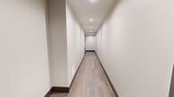 Located in the heart of downtown Dallas on Elm Street, this sophisticated high-rise residence offers two bedrooms, one bathroom, and a thoughtfully designed open-concept layout. Floor-to-ceiling windows throughout flood the space with natural light and frame breathtaking panoramic views of the Dallas skyline.

The kitchen and living area form a seamless open plan, anchored by a striking waterfall-edge island with a built-in sink. Custom grey cabinetry, stainless steel appliances including a French door refrigerator, built-in microwave, and range, a white tile backsplash, and a wine cooler complete this chef-inspired space. Rich hardwood flooring runs throughout the main living areas.

The primary bedroom is generously proportioned, featuring large windows with roller shades, a ceiling fan, and direct access to a walk-in closet outfitted with built-in shelving. A second walk-in closet with natural light provides additional storage. The bathroom is elegantly appointed with large-format white tile flooring, a dark wood vanity, marble countertops, a framed mirror, and a glass-enclosed walk-in shower with designer tile.

The second bedroom also benefits from expansive city views and plush carpeting. The overall aesthetic is clean, contemporary, and refined throughout.