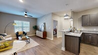 Located at 4950 Weaver Rd in Lake Charles, Louisiana, this 1-bedroom, 1-bathroom residence offers a smartly designed open-concept layout that maximizes every square foot. Wood-look flooring flows continuously throughout the space, tying each room together with a warm, cohesive aesthetic.

The kitchen is a functional centerpiece, featuring dark espresso cabinetry, granite countertops, a peninsula breakfast bar with pendant lighting overhead, and full black appliances including a refrigerator, range, and microwave. The adjacent living area benefits from natural light streaming through blinded windows and is finished with a ceiling fan for year-round comfort.

The bedroom offers a calm, restful retreat with its own ceiling fan, neutral wall tones, and direct access to the bathroom. The bathroom is cleanly appointed with granite countertops consistent with the kitchen's finishes and a tub/shower combination.

A dedicated laundry room houses a full-size washer and dryer, adding notable convenience. A separate closet provides additional storage. Neutral gray walls throughout create a versatile backdrop that complements a range of décor styles. The overall ambiance is modern, clean, and comfortable—ideal for those seeking a practical yet polished living space in Lake Charles.