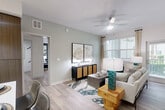 Located at 222 Courtney Lakes Cir in West Palm Beach, FL, this thoughtfully designed three-bedroom, two-bathroom single-floor residence offers a comfortable and modern living experience. Light wood-tone flooring flows throughout, creating a cohesive and airy atmosphere.

The living room is bright and welcoming, featuring large windows that invite natural light, a ceiling fan, and soft sage-green walls that lend a calm, coastal feel. The kitchen is a standout space, boasting rich wood-tone cabinetry extending to the ceiling, white quartz countertops, a tiled backsplash, stainless steel appliances, and a skylight that fills the room with natural light. A central island with bar seating provides additional dining and prep space.

The primary bedroom is generously sized, highlighted by a bold teal accent wall and a walk-in closet with multi-level shelving. A second bedroom features a textured dark accent wall paired with warm wood furnishings for a modern, serene retreat. A spacious walk-in closet with wire shelving offers ample storage.

The bathrooms are well-appointed, with one featuring a dual-sink vanity with warm wood cabinetry, white countertops, and a large framed mirror. In-unit laundry is also conveniently accessible from the hallway. This home combines functional design with stylish finishes throughout.