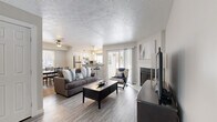 This thoughtfully designed 2-bedroom, 2-bathroom single-floor residence offers a comfortable and functional layout across its efficiently utilized footprint. The open-concept living area serves as the heart of the home, featuring durable wood-look flooring, a textured ceiling, and a fireplace flanked by a sliding glass door that fills the space with natural light and provides outdoor access. The kitchen is well-equipped with white shaker-style cabinetry, granite-look countertops, a subway tile backsplash, stainless steel appliances, and a breakfast bar that connects seamlessly to the adjoining dining area. The dining room offers a bright, windowed nook ideal for everyday meals or entertaining. Both bedrooms are carpeted and generously sized, with the primary bedroom offering ample space and multiple windows with outdoor views. The bathrooms are clean and modern, featuring white cabinetry, granite-look countertops, and well-lit vanity mirrors. A dedicated closet provides additional storage. Throughout the residence, a neutral color palette and consistent finishes create a cohesive, inviting ambiance suited for comfortable everyday living.