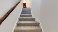 This three-story home is thoughtfully laid out across three distinct levels, offering a functional and comfortable floor plan for everyday living. The ground level features an attached garage with ample storage capacity, along with a versatile living area with plush carpeting, recessed lighting, and clean white walls — ideal for a lounge or recreation space.

The main level is the heart of the home, featuring an open-concept layout that seamlessly connects the kitchen, dining room, and living room. The kitchen is well-equipped with rich dark cabinetry, stainless steel appliances, a light countertop island with bar seating, and wood-look flooring. The dining area is an elegant space anchored by a classic chandelier and large window that fills the room with natural light. The living room is bright and inviting, with recessed lighting and large windows offering outdoor views.

The upper level hosts three bedrooms and additional bathrooms. The bedrooms are comfortable and well-sized, with carpeted floors and ample closet space. The bathrooms feature dark wood vanities with white countertops and tile flooring. Soft-carpeted staircases with a warm wood handrail connect all three floors, adding a classic finishing touch throughout the home.