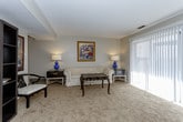 This single-floor residence offers a thoughtfully organized layout that balances comfort and functionality throughout. The open living area is carpeted and generously proportioned, bathed in natural light streaming through large windows with vertical blinds, and accented by a ceiling fan. It flows seamlessly into a dedicated dining space, creating an ideal environment for both relaxing and entertaining.

The kitchen is well-equipped with dark cabinetry, granite-style countertops, a white tile backsplash, and a full suite of stainless steel appliances including a gas range, over-the-range microwave, and a full-size refrigerator. Light tile flooring completes the clean, functional aesthetic.

The residence includes two carpeted bedrooms, each offering a calm, neutral palette. The primary bedroom features a walk-in closet and direct access to an en-suite bathroom, while a wall sconce adds a warm ambient glow. The second bedroom is equally comfortable, with a bright window and convenient closet access.

Two bathrooms serve the home: the en-suite includes a shower-tub combination with a sliding glass door, and the second bathroom features a vanity with dark cabinetry and tile flooring. Both are finished with neutral tones for a clean, cohesive look throughout the home.
