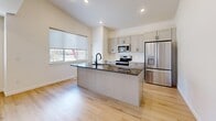 Located in Heber City, Utah, this well-designed three-story home offers five bedrooms and four bathrooms with a clean, modern aesthetic throughout. The main level features an open-concept kitchen and living area anchored by a large island with dark granite countertops, a built-in sink, and stainless steel appliances including a range, microwave, and French door refrigerator. Gray shaker-style cabinetry and a white subway tile backsplash complement the light hardwood flooring that flows through the main living spaces. Natural light enters through roller shade-fitted windows with views of the surrounding Heber Valley landscape. The upper floor hosts the primary bedroom suite and additional bedrooms, all carpeted and bright, with generous closet space — including walk-in closets with built-in rods. The bathrooms are finished with marble-look tile flooring, gray shaker vanities with matte black hardware, and white subway-tiled tub surrounds. The lower level provides a spacious family room with the same light hardwood flooring and recessed lighting, ideal for flexible use. A dedicated laundry room and abundant closet storage throughout the home add to its functional layout. The home's neutral palette and modern finishes create a cohesive, move-in-ready feel.