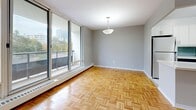 Located at 25 St Dennis Dr in Toronto's Don Mills neighbourhood, this well-appointed 2-bedroom, 2-bathroom unit offers a comfortable and thoughtfully designed layout across a single floor. Classic parquet wood flooring flows throughout the living areas and bedrooms, adding warmth and character to the space.

The open living and dining area is bright and generously sized, anchored by a wall of floor-to-ceiling sliding glass doors that lead to a private balcony overlooking lush, tree-lined surroundings. The kitchen is fitted with white cabinetry, a blue subway tile backsplash, marble-style flooring, and stainless steel appliances including a dishwasher and range.

The primary bedroom is spacious and well-lit, benefiting from a large window with outdoor views and baseboard heating. The second bedroom also features parquet flooring, natural light, and a built-in closet. Both bedrooms offer generous storage with multiple closets throughout the unit.

The bathrooms are finished with marble-style tile, including a full bathtub and shower surround with elegant veining detail. The overall aesthetic is clean and modern, with neutral grey walls providing a versatile backdrop throughout. The unit also includes four closets, offering ample storage for everyday living.