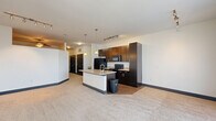 Located at 881 Third Ave SW in Carmel, Indiana, this one-bedroom, one-bathroom residence offers a thoughtfully designed single-floor layout that maximizes both function and style. The open-concept living area seamlessly connects the kitchen, dining, and living spaces, creating a bright and airy atmosphere. The kitchen is a standout feature, showcasing rich dark cabinetry that reaches toward the ceiling, black appliances, track lighting, and a central island with a light granite countertop and pendant lighting overhead — ideal for meal prep and casual dining. The living room is carpeted and bathed in natural light through large windows and a sliding glass door, and is finished with a ceiling fan for added comfort. A distinctive barn-style sliding door adds a modern-industrial accent to the hallway, which leads to three closets and an in-unit laundry area. The bedroom offers a cozy, well-proportioned retreat with a dedicated closet featuring built-in shelving and a hanging rod. The bathroom is clean and contemporary, appointed with large-format tile flooring, a dark-framed vanity with a white countertop, a soaking tub with tile surround, and brushed nickel fixtures throughout. This well-appointed residence combines practical storage solutions with a cohesive, modern design aesthetic.