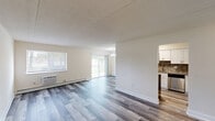 This well-appointed three-bedroom, two-bathroom residence at 3120 Naamans Rd in Wilmington, Delaware offers a thoughtfully designed single-floor layout. The open-concept combined living and dining area is a standout feature, showcasing durable hardwood-style flooring, neutral walls, a textured ceiling, and multiple windows that flood the space with natural light. Sliding glass doors lead to an outdoor area, enhancing the sense of openness. The kitchen is well-equipped with crisp white shaker cabinetry, a decorative mosaic tile backsplash, stone-look countertops, stainless steel appliances including a gas range and dishwasher, and an adjoining pantry for added storage. The three bedrooms offer comfortable proportions—the primary bedroom being notably spacious—with plush carpeting, generous windows, and individual closets, of which there are six throughout the residence. Both bathrooms are cleanly finished, featuring white subway tile surrounds with mosaic accent borders, a tub-shower combination, white vanities, and mirrored medicine cabinets. A central hallway connects all rooms efficiently. The overall ambiance is bright, clean, and move-in ready, with a functional layout well-suited for everyday living.