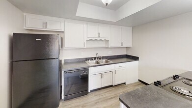 Modern kitchen with sleek black appliances, ample white cabinetry, and a spacious countertop for culinary enthusiasts. - Oak Park