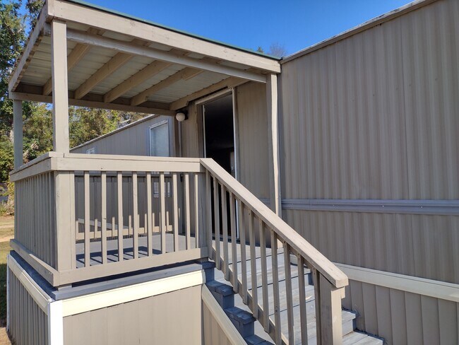 Puerta de entrada principal con un gran porche cubierto. - 716 N Houston Lake Blvd