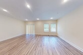 Located at 6 Truman Circle in Rochester, NH, this three-bedroom, three-bathroom home spans three floors, offering a generous and well-organized layout. The exterior presents a clean, neutral vinyl-sided facade with a covered entryway and landscaped surroundings. The main level hosts a combined kitchen and living room, where light hardwood-style flooring flows throughout. The kitchen is equipped with warm honey-toned cabinetry, granite countertops, and stainless steel appliances, including a refrigerator and dishwasher. The adjacent living area features recessed lighting, vertical blinds, and windows that invite natural light and views of the surrounding greenery. The bathrooms are finished with tile flooring, wood vanities topped with granite countertops, and clean, neutral wall tones. The bedrooms are carpeted and bright, with the spacious primary bedroom offering a comfortable private retreat. Hallways connect each level efficiently via a central staircase. The unfinished basement provides substantial utility space with exposed concrete walls and insulated ceilings, ideal for storage or future development. An attached garage adds everyday convenience. Throughout the home, a consistent palette of warm beige walls and white trim creates a cohesive, welcoming atmosphere.