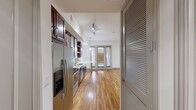 This 430 square foot apartment in Dallas, TX offers a blend of compact living and modern amenities. The single-floor layout maximizes space efficiency, featuring an open concept design that seamlessly integrates the living areas. The standout feature is the sleek, contemporary kitchen, equipped with stainless steel appliances, rich wood cabinetry, and a stylish mosaic tile backsplash. The apartment boasts beautiful hardwood floors throughout, adding warmth and continuity to the space. High ceilings and recessed lighting contribute to a sense of spaciousness. Large windows, some with blinds, allow ample natural light to flood the interior. A ceiling fan provides additional comfort. The white walls create a clean, neutral backdrop, perfect for personalization. Notable is the smart thermostat, indicating modern climate control. While compact, the thoughtful design ensures functionality without sacrificing style, making it an ideal urban dwelling for those seeking a contemporary living space in the heart of Dallas.