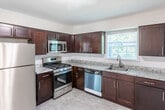 This single-floor residence on Horizon Dr in Edison, NJ offers a well-designed layout with a clean, updated aesthetic throughout. The open floor plan, visible in the 3D overview, connects the main living and dining areas seamlessly, both finished with warm hardwood flooring that extends through the bedrooms and common spaces. The living room is a bright, open area highlighted by sliding glass doors that lead directly to a private outdoor deck, allowing natural light to fill the space and offering easy access to the exterior.

The dining area features a contemporary chandelier and a large window framing views of the surrounding greenery. The kitchen has been thoughtfully renovated with rich, dark espresso cabinetry, granite countertops, and a full suite of stainless steel appliances including a gas range, built-in microwave, dishwasher, and refrigerator. A window above the sink brings in additional natural light.

The bedrooms continue the hardwood flooring and include generous closet space with bifold doors. Each room is served by baseboard heating and wall-unit air conditioning. The bathroom is finished with large-format tile in the shower-tub surround and on the floor, paired with a dark-cabinetry vanity and white countertop for a clean, modern look.