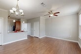 Located at 24929 Katy Ranch Rd in Katy, TX, this single-story 2-bedroom, 2-bathroom home offers a practical and comfortable layout. The open-concept living and dining area is bright and welcoming, featuring warm wood-look flooring, crown molding, a ceiling fan, and an elegant chandelier. Multiple windows along the front of the living room allow natural light to flow in, creating an airy atmosphere. The kitchen is equipped with rich cherry-toned cabinetry, granite-style countertops, stainless steel appliances, and a convenient breakfast bar that connects seamlessly to the dining and living spaces. Both bedrooms are generously sized, each featuring ceiling fans, wood-look flooring, and ample natural light. The spacious primary bedroom connects to a well-appointed bathroom with warm wood cabinetry, a wide vanity, and a full bathtub. Three closets provide abundant storage, including a large walk-in closet with wire shelving. A dedicated laundry room accommodates full-size appliances with additional overhead shelving for convenience. A utility room and hallway complete the thoughtful floor plan. Neutral gray walls throughout create a cohesive, move-in-ready aesthetic suited for a variety of décor styles.