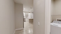 Located at Vineland Resort Way in Orlando, Florida, this single-floor residence offers three bedrooms, two bathrooms, and a well-planned layout designed for comfortable everyday living. Light wood-look tile flooring flows consistently throughout the home, creating a bright and cohesive aesthetic.

The open-concept kitchen and living area serves as the heart of the home. The kitchen features white cabinetry, a central island with pendant lighting, stainless steel appliances including a refrigerator, range, microwave, and dishwasher, and a clean white countertop that extends to a dedicated sink area with open shelving.

The living room receives ample natural light through large windows fitted with blinds, and is equipped with a ceiling fan. A door from the living area provides direct outdoor access.

The primary bedroom is a generously sized retreat, also featuring a ceiling fan and natural light. It connects to a walk-in closet outfitted with wire shelving systems that maximize storage capacity. Additional bedrooms are well-proportioned, each with closet access and ceiling fans.

The bathrooms are finished with neutral tile, including a tub-shower combination with marble-style tile surround, a single-sink vanity with white countertop, and wood-look flooring. A dedicated in-unit laundry room accommodates a full-size washer and dryer side by side, adding everyday convenience to this thoughtfully designed home.