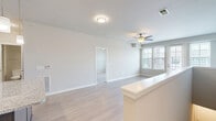 Located at 405 Smith Rd in Saint Charles, IL, this well-appointed 1-bedroom, 1-bathroom two-story residence offers a thoughtfully designed layout across its two levels. The main living floor showcases an open-concept kitchen and living room that flows seamlessly together. The kitchen is equipped with dark espresso cabinetry, granite countertops, stainless steel appliances including a refrigerator, microwave, and range, as well as a central island with pendant lighting overhead — ideal for both cooking and casual dining. Light wood-style flooring runs throughout the main living areas, complementing the neutral color palette and enhancing the bright, airy atmosphere. The living room benefits from large windows and French doors that invite abundant natural light, along with a ceiling fan for added comfort. The spacious primary bedroom features plush carpeting, a ceiling fan, and large windows with exterior views. Two closets provide generous storage, including a walk-in closet with wire shelving systems. The full bathroom is finished with a granite-topped dark vanity, a tub-shower combination, and light wood-style flooring. A staircase connects the entry level to the main living floor, completing this functional and stylish Saint Charles residence.