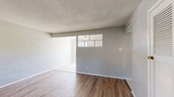 Located at 5217 Gunter Ave in El Paso, TX, this two-bedroom, one-bathroom home offers a practical single-floor layout with a variety of flooring surfaces throughout. The living room welcomes you with warm wood-look hardwood-style flooring, textured ceilings, and a window that brings in natural light and exterior views. Painted cinder block walls add a distinctive, sturdy character to the living areas. A louvered closet door and a front entry with a tile landing round out the functional design of this space. The kitchen is bright and efficient, featuring white cabinetry, a subway tile backsplash, granite-look countertops, a gas range, and a ceiling fan. A window above the counter fills the room with natural light. Both bedrooms are carpeted for comfort and each includes windows that allow sunlight in; one bedroom features a ceiling fan and exposed cinder block walls for added texture. The shared bathroom includes a vanity with stone-look counters, tile flooring, tile wainscoting, and a tub-shower combination. A connecting hallway ties the layout together seamlessly, making this home a straightforward and functional living space.