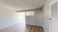 Located at 5217 Gunter Ave in El Paso, TX, this two-bedroom, one-bathroom home offers a practical single-floor layout with a variety of flooring surfaces throughout. The living room welcomes you with warm wood-look hardwood-style flooring, textured ceilings, and a window that brings in natural light and exterior views. Painted cinder block walls add a distinctive, sturdy character to the living areas. A louvered closet door and a front entry with a tile landing round out the functional design of this space. The kitchen is bright and efficient, featuring white cabinetry, a subway tile backsplash, granite-look countertops, a gas range, and a ceiling fan. A window above the counter fills the room with natural light. Both bedrooms are carpeted for comfort and each includes windows that allow sunlight in; one bedroom features a ceiling fan and exposed cinder block walls for added texture. The shared bathroom includes a vanity with stone-look counters, tile flooring, tile wainscoting, and a tub-shower combination. A connecting hallway ties the layout together seamlessly, making this home a straightforward and functional living space.
