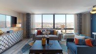 This thoughtfully designed single-floor residence offers a compelling blend of contemporary style and functional living. The centerpiece of the home is the expansive living room, where large floor-to-ceiling windows frame sweeping panoramic city views, flooding the space with abundant natural light. The living area accommodates generous seating arrangements and features light wood-style flooring that carries throughout the residence, complemented by a ceiling fan that adds both comfort and character.

Adjacent to the living room, the dining area provides an intimate setting for entertaining, illuminated by stylish track lighting and accented by curated wall art. The kitchen is outfitted with rich warm-toned wood cabinetry, granite countertops, and a stainless steel sink, offering ample storage and prep space. An in-unit washer is conveniently integrated within the kitchen layout.

The bedroom is a warm and inviting retreat, distinguished by a bold accent wall and large windows that continue the theme of expansive city views. A built-in closet provides practical storage. The full bathroom features a tiled tub-shower combination, wood-toned vanity cabinetry, and tasteful finishes throughout. Overall, the residence presents a cohesive, modern aesthetic with vibrant design details and a strong connection to the urban landscape beyond.
