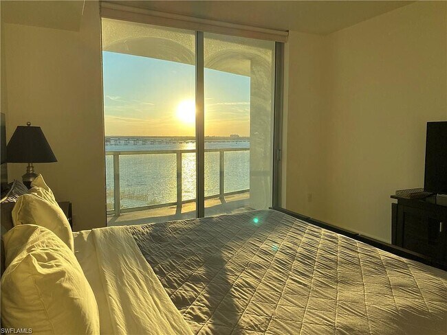 Dormitorio principal con vistas al río y al atardecer. - 2825 Palm Beach Blvd