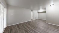 Located at 3523 Fawn Valley Dr in Dallas, Texas, this one-bedroom, one-bathroom unit offers a well-organized single-floor layout comprising a living room, bedroom, kitchen, bathroom, closet, and hallway. Throughout the unit, wood-look laminate flooring in a warm gray tone provides a cohesive and modern aesthetic, complemented by neutral gray walls and white trim.

The living room is a generously proportioned space featuring a textured ceiling, a flush-mount light fixture, and a set of French doors that invite natural light and provide outdoor access. A separate entry door adds functionality to the layout.

The galley-style kitchen is efficiently designed with white shaker-style cabinetry, light stone-patterned countertops, a stainless steel sink, and black appliances including a refrigerator and electric range — maximizing storage and workspace within a compact footprint.

The bedroom is a comfortable, well-sized room with wood-look flooring, a window fitted with horizontal blinds, and an exposed brick accent wall that adds a distinctive architectural character. A dedicated closet is conveniently accessible from the bedroom.

The bathroom features white tile surrounding a full tub-shower combination, a toilet, and a vanity with a light stone countertop, all set on clean white tile flooring. The overall design is straightforward, functional, and move-in ready.