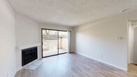 Located in Lancaster, CA, this well-appointed one-bedroom, one-bathroom residence offers a thoughtfully organized single-floor layout designed for comfortable everyday living. The living room serves as the heart of the home, featuring a classic fireplace with a marble-style hearth, light-toned vinyl plank flooring, and a textured ceiling. A sliding glass door floods the space with natural light and opens directly onto a private balcony, providing a pleasant outdoor retreat. The dining area flows seamlessly from the living room, creating an open, connected feel. The kitchen is efficiently designed with crisp white cabinetry extending to the ceiling, light quartz countertops, and a full suite of stainless steel appliances including a gas range, built-in microwave, and refrigerator. The bedroom is carpeted for comfort, features a ceiling fan, a window with blinds for natural light and privacy, and provides direct access to the bathroom. The walk-in closet offers generous storage with dual hanging rods and built-in shelving. The bathroom is finished with a white vanity, light wood-look flooring, and a full tub-shower combination. An in-unit laundry area adds everyday convenience, completing this well-rounded residence.