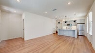 Located at 13939 FM-1560 in San Antonio, TX, this two-story home offers a well-designed layout across two floors. The main level features an open-concept kitchen and living area finished with light hardwood-style flooring and recessed lighting. The kitchen is a standout, showcasing gray shaker cabinetry, white subway tile backsplash, stainless steel appliances, a white quartz peninsula with an undermount sink, and sleek black pendant lighting. A bright entryway with a paneled front door and natural light from surrounding windows provides a welcoming arrival. An attached garage with an automatic opener offers convenient, secure parking. Upstairs, three carpeted bedrooms provide comfortable retreats, each with windows offering natural light. The spacious primary bedroom is complemented by a walk-in closet featuring built-in shelving and hanging rods for generous storage. Three full bathrooms are finished with tile flooring, white vanities, black hardware accents, and glass-enclosed walk-in showers. Multiple hallways and staircases connect the home's two levels efficiently. The clean, contemporary aesthetic is carried throughout, making this a cohesive and functional home.