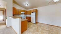Located at 1350 Great Plains Dr in Fox Crossing, WI, this 2-bedroom, 2-bathroom home offers a well-designed, single-floor layout with a thoughtful blend of functionality and comfort. The open-concept living area seamlessly connects the living room, dining area, and kitchen, creating a spacious and cohesive gathering space. Vaulted ceilings with ceiling fans enhance the airy feel, while large windows and a sliding glass door in the living room invite abundant natural light and provide access to a private balcony with outdoor views.

The kitchen is outfitted with warm honey-toned cabinetry, ample counter space, a full suite of white appliances including a dishwasher, range, and refrigerator, and a peninsula that serves as a natural divide between the kitchen and living spaces. The tile-style flooring in the kitchen transitions to plush carpeting throughout the living and bedroom areas.

The generously sized primary bedroom features a ceiling fan, baseboard heating, and a spacious walk-in closet with wire shelving. The primary bathroom includes a dual-sink vanity with wood cabinetry. The second bedroom also includes a ceiling fan, natural light, and a sliding door closet. A second full bathroom with a soaking tub completes the layout, along with a dedicated laundry room for added convenience.