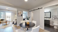 Located at 15 Cooper's Town Road in Winnipeg, this well-appointed 2-bedroom, 2-bathroom residence offers a thoughtfully designed single-level layout with modern finishes throughout. Light-toned hardwood flooring flows through the main living areas, complementing the clean, contemporary aesthetic of the space.

The living room serves as the heart of the home, featuring a large sliding glass door that opens to a private balcony, flooding the room with natural light. A bold accent wall adds depth and character to the space. Adjacent to the living area, a dedicated dining nook is highlighted by a stylish sliding barn door — a standout architectural detail that adds both function and visual interest.

The kitchen is equipped with stainless steel appliances, dual-tone cabinetry featuring glossy white upper cabinets and charcoal lower cabinets, white quartz countertops, and a classic subway tile backsplash — offering a polished, functional cooking space.

The generously sized primary bedroom features plush carpeting and a large window that draws in natural light. The second bedroom is equally comfortable, also carpeted and naturally lit. Both bathrooms are finished with dark-framed vanity mirrors, grey cabinetry, and clean white countertops, with one featuring a full soaker tub and shower combination.