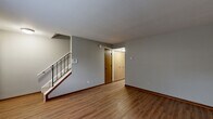 Located at 4880 Willow Glen Dr in Beech Grove, Indiana, this two-story home offers a practical and well-organized layout across two levels. The main floor features a welcoming living room with warm laminate wood flooring, a large window that invites natural light, and a staircase leading to the upper level. The kitchen is a functional highlight, showcasing wood-tone cabinetry — both upper and lower — paired with a light-colored peninsula countertop that doubles as a breakfast bar. Black appliances, including a range and refrigerator, complement the classic cabinetry. A hallway and bathroom complete the main floor. Upstairs, two carpeted bedrooms provide comfortable retreats. The generously sized primary bedroom features dual closets and ample space for a full furniture arrangement. The second bedroom also includes a closet and a window with outdoor views. Each floor is served by its own bathroom; one features a vanity with a large mirror and clean fixtures, while the other includes a full tub-shower combination with chrome hardware. Consistent warm wood trim throughout both floors ties the home together with a cohesive, understated aesthetic.