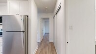 Located at 948 Esquimalt Road in Victoria, British Columbia, this well-appointed one-bedroom, one-bathroom unit offers a thoughtfully designed layout across a single floor. The living room is a standout space, bathed in natural light thanks to large windows and a sliding glass door that opens onto a private balcony overlooking lush greenery — an inviting extension of the interior living area. Light-toned hardwood-style flooring runs throughout, complementing the crisp white walls and creating a clean, airy atmosphere. Baseboard heating is present throughout the unit, ensuring comfortable warmth year-round. The generously sized bedroom features its own window with a view of mature trees, providing a calm and private retreat. A dedicated closet offers practical storage. The bathroom is finished to a high standard, featuring classic white subway tile surrounding a full soaker tub with an overhead shower and polished chrome fixtures — a timeless and functional design. The kitchen and entryway connect the spaces efficiently, contributing to the unit's practical and cohesive flow. Overall, the unit presents a bright, neutral palette and modern finishes that make it a comfortable and versatile living space in the heart of Victoria's Esquimalt neighbourhood.