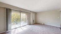 Located at 2215 Monyauk Rd in Roanoke, Virginia, this one-bedroom, two-bathroom unit offers a practical and well-organized single-level layout. The combined living and dining area serves as the heart of the home, featuring neutral-toned carpet, warm beige walls, and large sliding glass doors that open onto a private balcony overlooking mature trees — filling the space with natural light. A ceiling fan in the adjoining area provides additional airflow and comfort.

The bedroom is a comfortably sized retreat with a window that brings in natural light, soft carpet underfoot, and access to generous closet space. Four closets throughout the unit ensure abundant storage for residents.

The kitchen is equipped with wood-tone cabinetry, light speckled countertops, a stainless steel sink, and a dishwasher — offering functional efficiency in a compact footprint. Tile flooring grounds the kitchen area practically.

Both bathrooms feature tile flooring. One includes a full soaking tub with shower surround, while the other offers a vanity with under-sink storage, a lighted mirror, and an adjacent toilet — together providing convenient, split-use functionality. A hallway connects the rooms, contributing to the logical flow of this efficiently designed unit.