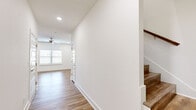 Located at 9549 Glen Rd in Bentonville, Arkansas, this well-appointed two-story home offers four bedrooms and three bathrooms across two thoughtfully designed floors. The main level features an open-concept kitchen and living area bathed in natural light from large windows. The kitchen is a standout, outfitted with gray shaker-style cabinetry, white quartz countertops, a subway tile backsplash, stainless steel appliances, and a double-basin sink. Warm wood-look luxury vinyl plank flooring flows consistently throughout both levels, lending a cohesive and modern aesthetic. Ceiling fans are present in the living area and bedrooms, enhancing comfort and airflow. The upper floor houses the majority of the bedrooms, including a generously sized primary suite with an en-suite bathroom featuring gray shaker vanity cabinetry, brushed nickel fixtures, a framed mirror, and a glass-enclosed walk-in shower. A dedicated walk-in closet with built-in shelving and hanging rods provides ample storage. Additional bedrooms are well-proportioned with natural light and ceiling fans. A dedicated laundry room with full-size washer and dryer hookups adds everyday convenience. Clean white walls, recessed lighting, and crisp trim work throughout give the home a fresh, move-in-ready feel.