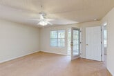 This single-story, one-bedroom home offers a thoughtfully organized layout across a comfortable footprint. The entrance opens into a tiled foyer that flows into the main living areas. The combined dining and living room is a bright, open space featuring plush carpeting, a textured ceiling, and a ceiling fan with light fixture. Large windows and a glass-paneled exterior door allow abundant natural light to fill the room, with views of surrounding greenery. A chandelier over the dining area adds a touch of elegance.

The galley-style kitchen is equipped with warm oak cabinetry, light countertops, a gas range, dishwasher, refrigerator, and built-in microwave, all set on tile flooring. A pass-through counter connects it conveniently to the dining area.

The generously sized bedroom features soft carpeting, a ceiling fan, a window for natural light, and direct access to the bathroom. The full bathroom includes a vanity with storage, tile flooring, and a tub/shower combination.

Two closets provide ample storage, including a walk-in closet outfitted with wire shelving. A dedicated laundry room with tile flooring, shelving, and an electrical panel offers added practicality. A separate utility room completes the home's practical offerings.