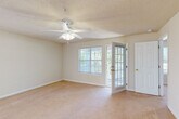 This single-story, one-bedroom home offers a thoughtfully organized layout across a comfortable footprint. The entrance opens into a tiled foyer that flows into the main living areas. The combined dining and living room is a bright, open space featuring plush carpeting, a textured ceiling, and a ceiling fan with light fixture. Large windows and a glass-paneled exterior door allow abundant natural light to fill the room, with views of surrounding greenery. A chandelier over the dining area adds a touch of elegance.

The galley-style kitchen is equipped with warm oak cabinetry, light countertops, a gas range, dishwasher, refrigerator, and built-in microwave, all set on tile flooring. A pass-through counter connects it conveniently to the dining area.

The generously sized bedroom features soft carpeting, a ceiling fan, a window for natural light, and direct access to the bathroom. The full bathroom includes a vanity with storage, tile flooring, and a tub/shower combination.

Two closets provide ample storage, including a walk-in closet outfitted with wire shelving. A dedicated laundry room with tile flooring, shelving, and an electrical panel offers added practicality. A separate utility room completes the home's practical offerings.