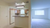 This single-floor residence features a functional and open layout that connects the kitchen and living areas seamlessly. The kitchen is equipped with warm wood-toned cabinetry, a tile backsplash, and light-toned countertops that extend into a peninsula-style breakfast bar, offering a practical space for casual dining or meal prep. White appliances, including a full-size refrigerator and built-in microwave, complement the clean aesthetic. Recessed and flush-mount ceiling lighting provides ample illumination throughout the kitchen, while a window above the sink introduces natural light and a view of surrounding greenery. Tile flooring in the kitchen transitions into plush carpeting as the space opens toward the adjacent living area. The living area benefits from a large window dressed with vertical blinds, allowing for adjustable natural light. Neutral wall tones throughout create a bright and cohesive atmosphere. The overall design prioritizes an efficient use of space while maintaining a comfortable, move-in-ready feel suitable for everyday living.