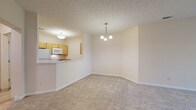 Located at 500 Aqua Marine Blvd in Avon Lake, Ohio, this single-floor unit offers a well-organized layout designed for comfortable everyday living. The open dining area is anchored by a modest chandelier and flows seamlessly into the living space, both finished with neutral-toned wall-to-wall carpeting that carries throughout the bedroom areas. Textured ceilings add a classic touch consistent across the main living spaces.

The kitchen features light maple cabinetry, laminate countertops, and white appliances including a refrigerator, range, and built-in microwave. A pass-through counter connects the kitchen to the dining area, enhancing the open feel. Tile flooring extends through the kitchen and into a utility hallway, where a full-size washer and dryer are conveniently housed alongside closet and interior door access.

The bedrooms are generously sized, with large windows that invite natural light and views of surrounding greenery. One bedroom features notably elevated ceilings, lending a more spacious feel.

Two bathrooms serve the unit: one with a tub-shower combination, single vanity, and tile flooring, and a second with a glass-door shower enclosure and a wider vanity with drawer storage. Both bathrooms maintain a clean, neutral palette with brushed nickel fixtures throughout.