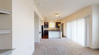 This well-appointed 1-bedroom, 1-bathroom unit in Broomfield, Colorado offers a thoughtfully designed open-concept layout. The combined kitchen and living area serves as the heart of the home, where rich hardwood flooring anchors the kitchen space while plush carpeting extends into the living area. The kitchen is highlighted by dark espresso cabinetry, granite countertops, a tile backsplash, and a peninsula with pendant lighting overhead — ideal for casual dining or meal prep. Black appliances, including a refrigerator, range, and built-in microwave, complete the functional kitchen setup. A track lighting system provides additional illumination throughout the space. The spacious primary bedroom is generously sized, featuring soft carpet flooring, a ceiling fan, and multiple windows dressed with blinds that allow for ample natural light. A dedicated closet offers convenient storage. The hallway connects the living areas to the bedroom, providing a well-organized flow throughout the unit. Neutral wall tones and clean lines create a bright, welcoming ambiance, making this Broomfield residence a comfortable and practical living space.