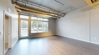 Located at 3029 22nd Ave S in Minneapolis, MN, this one-bedroom, one-bathroom unit offers a thoughtfully designed layout across a single floor. The open-concept living, dining, and kitchen area is defined by an industrial-inspired aesthetic, showcasing exposed concrete ceilings with visible ductwork and conduit, paired with sleek wood-look flooring and neutral gray tones throughout. Large windows flood the living space with natural light and provide views of the surrounding neighborhood. The kitchen is well-appointed with rich dark-wood cabinetry, granite countertops, and a full suite of stainless steel appliances including a range, microwave, and dishwasher. The bedroom features plush carpet flooring, a dedicated walk-in closet with built-in shelving, and a window that brings in additional natural light. The full bathroom includes a vanity with matching dark cabinetry, a combination tub and shower, and wood-look tile flooring. Additional conveniences include in-unit laundry, a utility room, two closets for ample storage, and a private patio. This unit blends modern finishes with urban industrial character for a distinctive living experience.