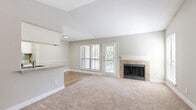 Located in Katy, TX, this 2-bedroom, 2-bathroom single-level home offers a thoughtfully laid-out floor plan with a warm, neutral palette throughout. The open living and dining area serves as the heart of the home, anchored by a tile-surround fireplace and bathed in natural light from large windows. A glass door leads directly to the private balcony, extending the living space outdoors. The galley-style kitchen is well-appointed with white cabinetry, granite countertops, stainless steel appliances, and wood-look flooring, offering both functionality and style. Plush carpeting runs through the living room and bedrooms, adding comfort underfoot. The spacious primary bedroom features vaulted ceilings, a ceiling fan, a large window with outdoor views, and an open closet with built-in shelving for generous storage. The second bedroom also offers vaulted ceilings, a ceiling fan, and easy hallway access. Both bathrooms are finished with granite-topped vanities and full tub-shower combinations with clean white tile surrounds. Additional highlights include four closets throughout, a dedicated laundry area, and multiple hallways that ensure a smooth, efficient flow across the entire residence.
