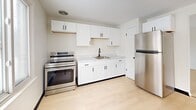 Located at 1175 George Urban Blvd in Buffalo, NY, this thoughtfully updated 2-bedroom, 1-bathroom unit offers a clean, modern aesthetic across a single floor. Light wood flooring flows consistently throughout every room, complemented by crisp white walls and dark accent hardware that create a fresh, cohesive look.

The kitchen is a standout feature, showcasing white shaker-style cabinetry, marble-look countertops, a single-basin sink, and a full suite of stainless steel appliances including an electric range and refrigerator. Natural light and ample cabinet storage make this an efficient and attractive cooking space.

Both bedrooms are bright and well-proportioned, each equipped with a ceiling fan and light fixture. The primary bedroom receives generous natural light through multiple windows offering outdoor views. The second bedroom also benefits from natural light and a ceiling fan, providing a comfortable and airy atmosphere.

The bathroom is clean and functional, featuring a white vanity with dark hardware, a tiled tub-surround shower combination, and light wood flooring that ties seamlessly to the rest of the unit.

A connecting hallway links all rooms efficiently, contributing to the unit's practical layout. Throughout the space, consistent finishes and an abundance of natural light create a welcoming, move-in-ready environment.