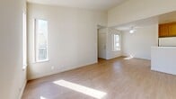 Located at 400 W Central Ave in Tracy, CA, this one-bedroom, one-bathroom residence offers a thoughtfully designed single-floor layout with a bright, open feel. Light-toned laminate flooring flows through the main living areas, enhancing the sense of openness. The combined living, dining, and kitchen area forms the heart of the home, where soaring ceilings add volume and dimension. The kitchen features warm honey-toned wood cabinetry, white appliances including a refrigerator, range, and dishwasher, and a peninsula that provides additional counter space and separates the kitchen from the living and dining areas. Large windows and a sliding glass door in the bedroom allow generous natural light to pour in, with the slider providing direct access to a private patio overlooking outdoor greenery. The bedroom is carpeted for comfort and includes a mirrored sliding-door closet. The bathroom is equipped with a single-sink vanity with matching wood cabinetry and light countertops. A dedicated entrance, hallway, and multiple closets throughout provide practical storage solutions. Additional utility spaces round out this efficiently planned and well-lit residence.