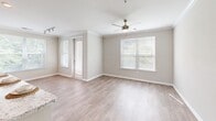 Located at 6880 Rivers Ave in North Charleston, SC, this single-story residence offers a thoughtfully designed floor plan with two bedrooms and two bathrooms across a comfortable and functional living space. Light wood-look flooring runs throughout, complementing neutral gray-beige walls and crisp white trim to create a clean, cohesive aesthetic.

The kitchen is a standout feature, showcasing rich dark-espresso cabinetry extending to the ceiling, granite-look countertops, black appliances, track lighting, and a peninsula with additional counter space and a sink — ideal for both meal preparation and casual dining. Crown molding adds a refined detail to the kitchen and adjoining living area, which benefits from multiple windows and a ceiling fan, filling the space with natural light.

Both bedrooms are generously proportioned, each equipped with ceiling fans and windows that bring in outdoor views and natural light. The primary bedroom connects to an en-suite bathroom featuring a granite-topped vanity with dark cabinetry, wood-look flooring, and a walk-in closet with built-in shelving. The second bathroom includes a full tub-shower combination, an open shelving unit, and matching granite countertops. Three hallways provide efficient circulation throughout the layout.