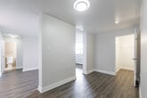 Located at 2 Quebec Street in Guelph, Ontario, this one-bedroom, one-bathroom unit offers a thoughtfully designed single-floor layout with modern, updated finishes throughout. The open-concept living and kitchen area forms the heart of the unit, featuring light-toned laminate flooring that flows seamlessly from room to room. The kitchen is equipped with crisp white shaker-style cabinetry, dark countertops, a subway tile backsplash, a stainless steel refrigerator, and a dishwasher — offering a clean, contemporary aesthetic. The living area is bright and airy, benefiting from large windows that invite generous natural light and provide views of the surrounding Guelph cityscape. A private exterior door in the living space adds a convenient access point. The bedroom is a comfortable, well-proportioned space with its own large window, baseboard heating, and the same warm laminate flooring. The bathroom is finished with neutral large-format wall tiles, a white vanity with granite-style countertop, a wide mirror, and accessible grab bars for added practicality. Additional white cabinetry in the unit provides practical storage. Baseboard heating throughout ensures year-round comfort. The overall ambiance is clean, bright, and move-in ready, making this an efficient and functional urban home in the heart of Guelph.