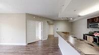 This well-designed apartment in Orlando, FL offers 890 square feet of comfortable living space. The open floor plan seamlessly connects the living area and kitchen, creating a spacious feel. The modern kitchen features dark wood cabinetry, stainless steel appliances, and a convenient breakfast bar.

The primary bedroom, measuring 150 square feet, provides ample space and is equipped with a ceiling fan for added comfort. Both bedrooms feature plush carpeting and large windows allowing natural light to flood in. The bathroom boasts a double vanity with ample storage and a large mirror.

A standout feature is the private balcony accessible through sliding glass doors, offering views of the surrounding greenery. The apartment also includes a dedicated laundry area with a full-sized washer and dryer.

Throughout the space, you'll find a cohesive design with neutral wall colors, wood-look flooring in main living areas, and carpeting in bedrooms. Ceiling fans in multiple rooms provide additional climate control options.

Located at 10203 Falcon Parc Blvd in Orlando, this single-story apartment combines modern amenities with a practical layout, making it an ideal home for those seeking comfort and convenience in the heart of Florida.