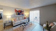 This single-story residence offers a thoughtfully arranged floor plan with distinct spaces for living, dining, cooking, and sleeping. The living room serves as the central gathering area, finished with light wood-style flooring, a textured ceiling, and a sliding glass door fitted with vertical blinds that opens to an outdoor patio, allowing natural light to fill the space. Adjacent to the living room is a dedicated dining area, complete with a ceiling fan and room for a full dining set.

The galley-style kitchen is efficiently designed with white cabinetry, light countertops, a stainless steel sink, and stainless steel appliances including a refrigerator and range. Light wood-style flooring continues throughout, contributing to a clean, cohesive aesthetic.

The primary bedroom features plush carpeting, neutral wall tones, and a textured ceiling, providing a calm retreat. A second bedroom, also carpeted, includes a window for natural light and a closet, offering practical versatility. The bathroom is straightforward and functional, featuring a full tub-shower combination with white tile surround. Throughout the unit, neutral tones and consistent finishes create a cohesive and comfortable living environment.
