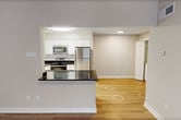 This 680 square foot apartment in Newport News, VA, offers a modern living space with thoughtful design elements. The single-floor layout comprises two bedrooms, including a primary bedroom of 140 square feet, one bathroom, and an open-concept living area. The kitchen showcases a contemporary aesthetic with white cabinetry, stainless steel appliances, and a striking contrast provided by dark countertops. Subway tile backsplash and recessed lighting add to the kitchen's updated feel. The bathroom features a clean, white design with a vanity, mirror, and combined shower-tub unit. Throughout the apartment, a mix of flooring types can be found, including warm wood-look floors in the main living areas and kitchen, and plush carpeting in the bedrooms. Large windows in the bedrooms allow for ample natural light, while blinds offer privacy control. The neutral color palette of the walls creates a bright, airy atmosphere throughout. Built-in closets provide storage solutions, and the layout maximizes the use of space in this efficiently designed apartment.